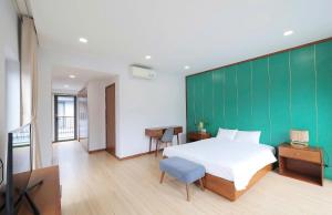 a bedroom with a bed and a green wall at Nova Villas Phu Quoc in Phú Quốc +39 photos