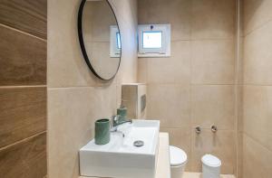 a bathroom with a white sink and a mirror at Athena's Studios 2 in Polychrono +18 photos