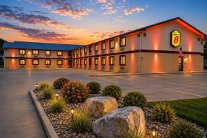 a hotel building with a parking lot and rocks at Super 8 by Wyndham Champaign in Champaign