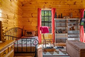 a bedroom with a bed and a window in a log cabin at Romantic Smoky Mtn Cabin Private Hot Tub Quiet Wooded Retreat in Sevierville