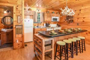 a kitchen with a center island with bar stools at Romantic Smoky Mtn Cabin Private Hot Tub Quiet Wooded Retreat in Sevierville