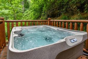 a hot tub sitting on top of a deck at Romantic Smoky Mtn Cabin Private Hot Tub Quiet Wooded Retreat in Sevierville
