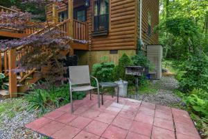 a patio with a chair and a grill in front of a house at Romantic Smoky Mtn Cabin Private Hot Tub Quiet Wooded Retreat in Sevierville +27 photos