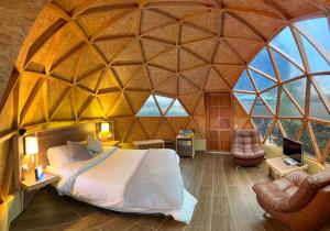a bedroom in a dome shaped room with a bed and chairs at Glamping Green Garden Suite in Villa de Leyva