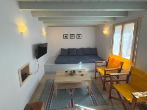 a small living room with a bed and a table at D BERNARDAKI Garden House in Mytilene