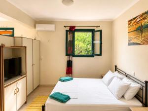 a small bedroom with a bed and a window at Nefeli’s guest house in Nydri