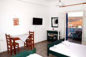 a living room with a table and chairs and a television at Litsas Studios Kythnos in Kithnos