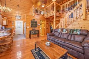 a living room with a couch and a table in a cabin at Breathtaking Views No-Stair Entry, Hot Tub, Pool Table & Seasonal Pool Access in Sevierville