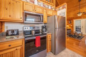 a kitchen with stainless steel appliances and wooden cabinets at Breathtaking Views No-Stair Entry, Hot Tub, Pool Table & Seasonal Pool Access in Sevierville +41 photos