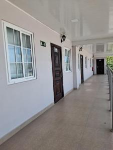a hallway of a white building with a door at Hotel Inter in Penonomé