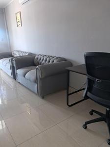 a living room with a couch and a desk and a chair at Hotel Inter in Penonomé
