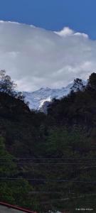 a snow covered mountain in the distance with at Bahram vatika in Sonprayag +10 photos