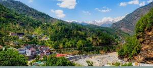 a view of a valley with a river and mountains at Bahram vatika in Sonprayag