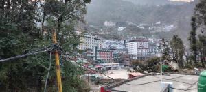 a view of a city with buildings on a mountain at Bahram vatika in Sonprayag
