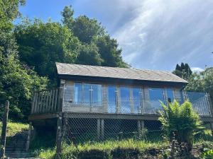 a small house with glass windows in a field at Portlea Cabin in Oban