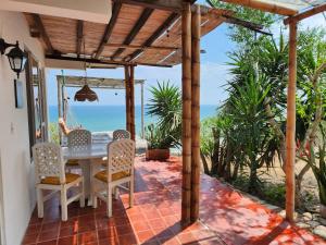a patio with a table and chairs and the ocean at Casa Las Mantas Santa Marianita in Santa Marianita