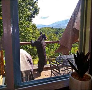 a bear standing on its hind legs on a balcony at Happy Trails Stunning Smoky Mtn Views Hot Tub Game Room Resort Pools in Gatlinburg