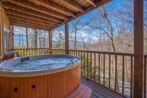 a hot tub on the deck of a cabin at Happy Trails Stunning Smoky Mtn Views Hot Tub Game Room Resort Pools in Gatlinburg