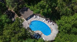 an overhead view of a swimming pool in the woods at Happy Trails Stunning Smoky Mtn Views Hot Tub Game Room Resort Pools in Gatlinburg
