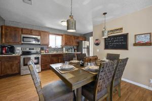 a kitchen with a wooden table with chairs and a dining room at Happy Trails Stunning Smoky Mtn Views Hot Tub Game Room Resort Pools in Gatlinburg