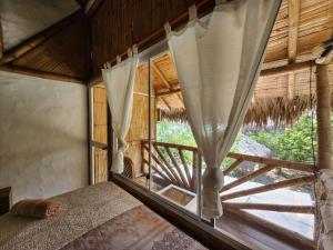 a bedroom with a bed and a large window at Casa Las Mantas Santa Marianita in Santa Marianita