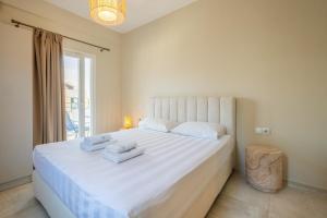a bedroom with a large white bed with towels on it at Athena's Studios 2 in Polychrono
