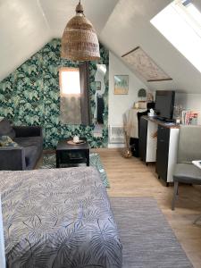 a room with a bed and a living room with a wall at chambre spacieuse indépendante PDJ inclus in Plougastel-Daoulas