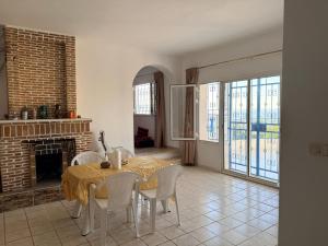 a dining room with a table and chairs and a fireplace at Villa rafraf al hmeri in Rafrāf