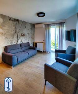 a living room with a blue couch and chairs at Casa Vacanze Antico Eremo, tra natura e tradizione in Campodenno