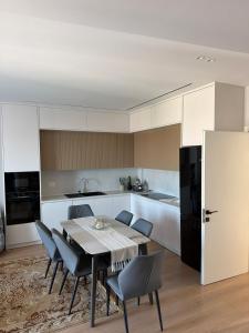 a kitchen with a dining room table and chairs at Apartment 51 Luxury in Kamëz