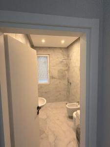 a bathroom with a tub and a toilet and a sink at Apartment 51 Luxury in Kamëz