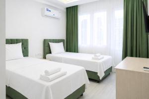 two beds in a room with green curtains at Hotel Angel Beach - Kızkalesi Mersin in Erdemli +18 photos