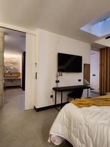 a bedroom with a bed and a desk and a television at La Kasilla in Baeza