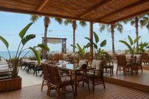 a restaurant with tables and chairs on a deck at Hotel Angel Beach - Kızkalesi Mersin in Erdemli