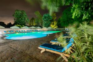 a swimming pool with blue lounge chairs in a resort at Q Hotel in Neptun