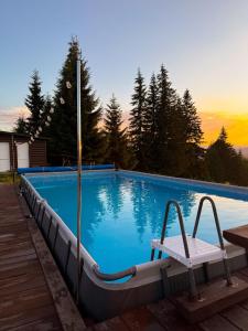 a swimming pool with a chair sitting on a deck at котедж Квітуча Гора in Yablunytsya