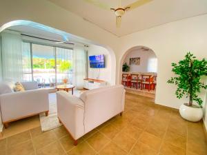 a living room with two white couches and a plant at 9 bedroom Villa in Mombasa