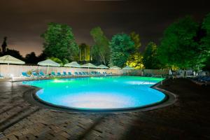 a swimming pool at night with blue lighting at Q Hotel in Neptun