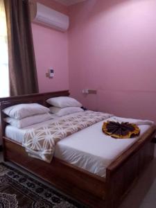 a bedroom with two beds in a room with pink walls at Katavi Empire Hotel in Mpanda