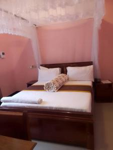 a bedroom with a bed with white sheets and pillows at Katavi Empire Hotel in Mpanda