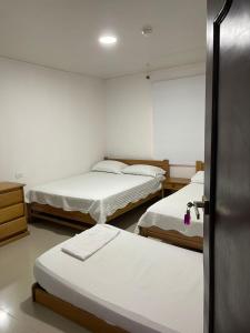 a room with three beds and a door open at yasa by SEA CRAB in San Andrés