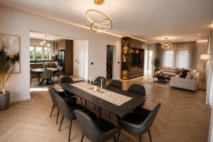 a dining room and living room with a table and chairs at Villa Krasta in Elbasan