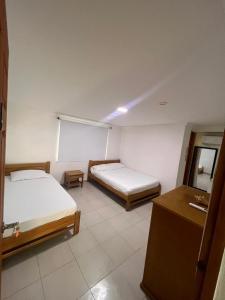a hotel room with two beds and a desk at yasa by SEA CRAB in San Andrés