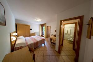ein Hotelzimmer mit Bett und Badezimmer in der Unterkunft Hotel & Appartamenti Al Larice in Ronzone