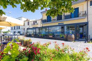 a building with a lot of windows and flowers at Marta Lake Albergo Diffuso & Spa in Marta