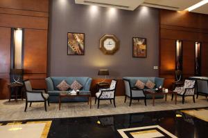 a waiting room with couches and chairs and a clock at Qaser Alhamra Hotel Riyadh in Riyadh