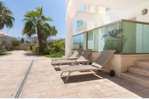 a row of chaise lounge chairs on a patio at סוויטת לה פלמורה in Eilat