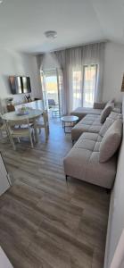 a living room with a couch and a dining room at Apartmani Furesti 2 in Donji Stoliv