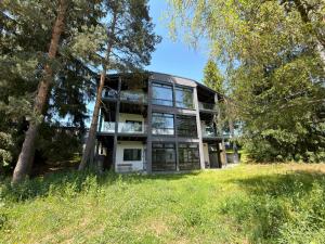 a house in the middle of a field with trees at Black Diamond Apartments in Kobylnice