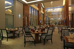 a dining room with tables and chairs in a restaurant at Qaser Alhamra Hotel Riyadh in Riyadh